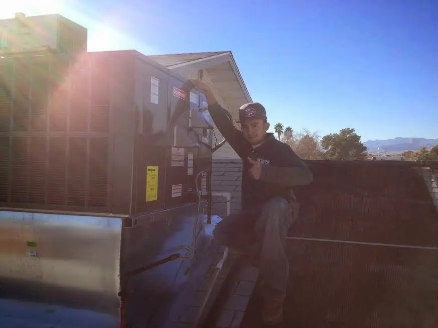 HVAC technician performing AC Tune-Up on a rooftop unit in Peabody